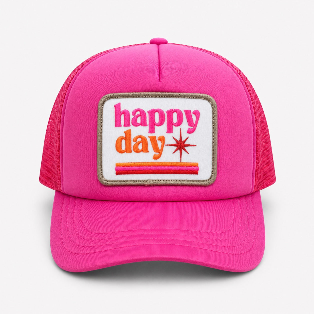 A bright pink trucker hat with a rectangular front patch reading 'happy day' in pink and orange text, shown on a light gray background.